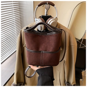 Detail of dark brown bucket bag with contrast stitching and matte suede texture