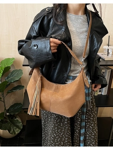 Detail of retro brown hobo bag featuring stylish fringe and silver studded shoulder strap