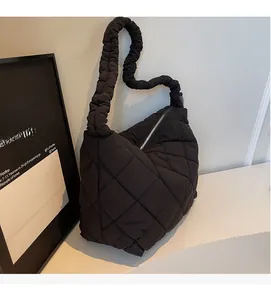 Detail of black quilted tote bag featuring a unique gathered cloud-style shoulder strap
