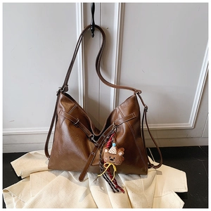 Close-up of brown PU tote bag featuring decorative white contrast stitching and a cute bear