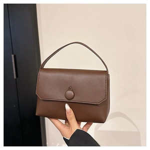 Detail shot of the dark brown leather texture and buckle on this stylish handbag
