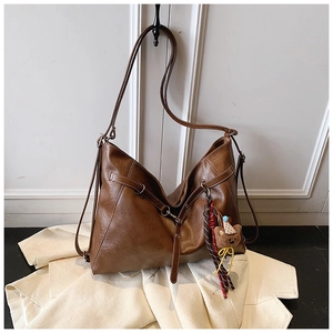 Detail view of brown PU leather hobo bag with silver buckle and cute plush bear charm