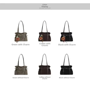 Detail view of large suede tote bags in green, coffee and black with charm options