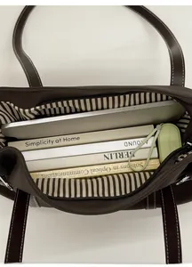 Interior view of brown tote bag showing striped lining and space for 14-inch laptop