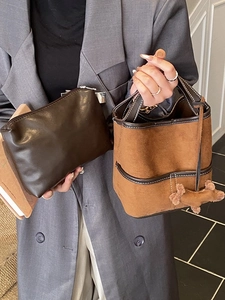 Chic brown leather bucket bag and clutched handbag with a cute dog pendant accessory