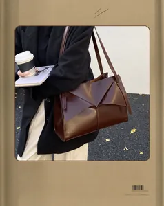 Dettaglio di una borsa tote vintage marrone scuro con patta geometrica a pieghe unica