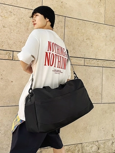 Large black sports travel bag with dry-wet separation shown on female model outdoors