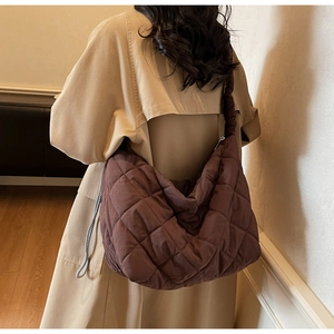 Brown quilted crossbody tote bag shown from a back view to display large storage capacity