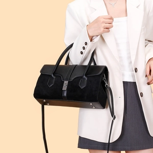Detail shot of a black matte textured tote bag with silver metal twist lock and studs