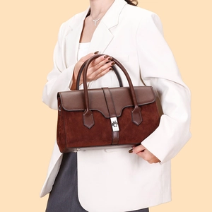 Detail of vintage brown leather and suede tote bag with silver rotary lock and dual handles