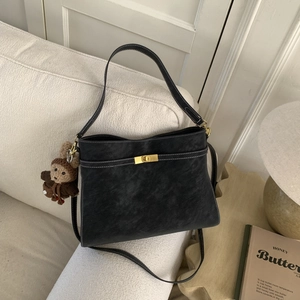 Détails du sac sous le bras en cuir noir avec coutures contrastées et fermoir doré
