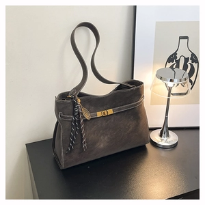 Detail of matte gray tote bag with contrast stitching and gold twist lock closure