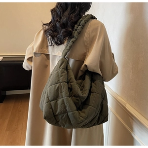 Close-up of olive green quilted puffer tote bag with scrunched shoulder strap detail