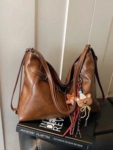 Retro brown leather shoulder bag with contrast stitching and plush bear charm