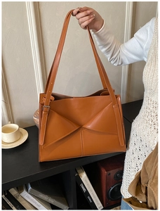 Dettaglio della borsa tote arancione con tasca frontale geometrica pieghevole unica