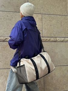 Large capacity off-white duffel bag with black straps and side mesh pocket for fitness travel
