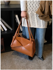 Dettaglio della borsa tote in pelle marrone con design geometrico in contesto reale