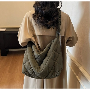 Quilted olive green tote bag featuring a padded puffy texture and ruched shoulder strap