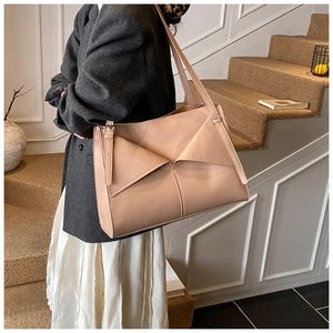 Dettaglio borsa tote beige con design a pieghe geometriche e tracolla sottile chic