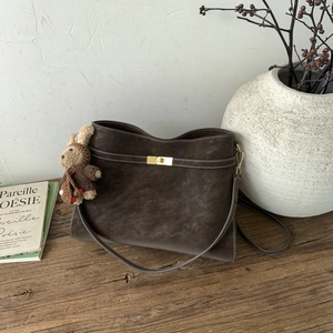 Détail du sac cabas marron foncé avec boucle dorée et breloque lapin en peluche