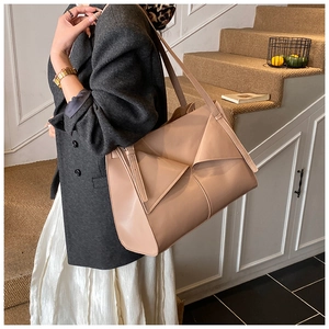 Dettaglio della borsa tote beige in pelle con patta geometrica e tracolla sottile