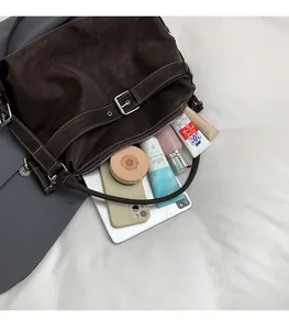 Top view of spacious dark brown suede hobo bag interior with personal essentials