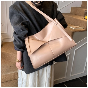 Dettaglio di una borsa tote pieghevole geometrica beige con il suo esclusivo design plissettato