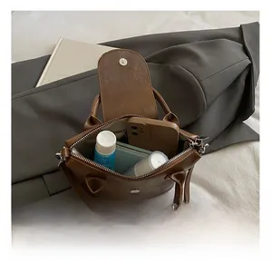 Detailed interior of brown leather crossbody bag showing large storage capacity
