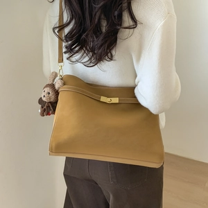 Détail du sac cabas en cuir camel avec surpiqûres blanches et breloque lapin en peluche