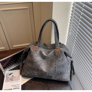 Détail du grand sac cabas gris rétro avec des clous argentés et finitions en cuir