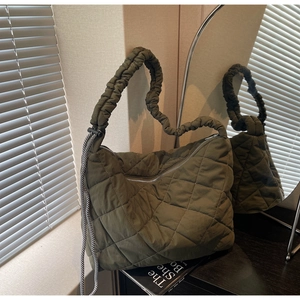 Detailed close-up of an olive green quilted tote with stylish side checkered drawstrings