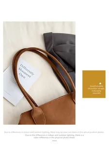 Détail d'une bandoulière large et plate avec surpiqûres sur un sac cabas marron chic