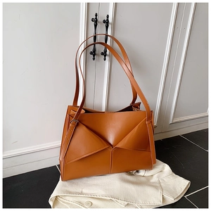Dettaglio borsa tote marrone in ecopelle con design a triangolo 3D e manici lunghi