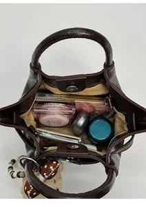 Internal view of dark brown pebbled leather bucket bag showing spacious storage and pockets