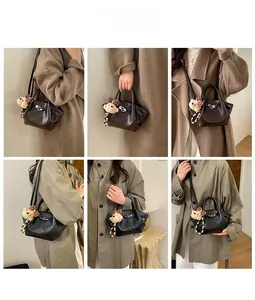 Detail view of leather bucket bag featuring a rotary lock and plush bear charm accessory