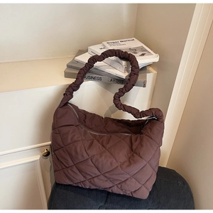 Detail of quilted dark chocolate padded tote bag with unique scrunched handle strap