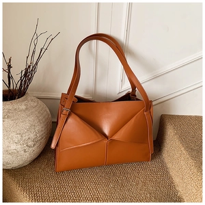 Dettaglio della borsa a spalla in pelle opaca color caramello con patta geometrica