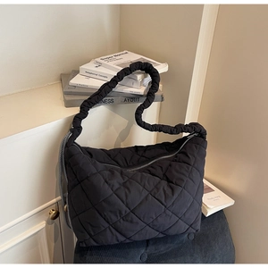 Detailed view of black quilted nylon tote bag with unique ruched scrunchie shoulder strap
