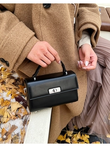Sac à main classique en cuir noir avec fermoir rotatif argenté dans un décor d'automne