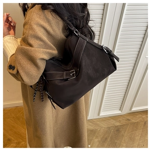 Detail of dark brown suede tote bag with contrast stitching and silver metal buckle