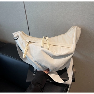 Detail of white nylon crescent bag showing triple zippers and woven cord pullers