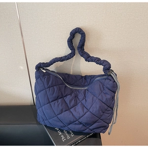 Detail of navy quilted tote bag featuring ruched cloud handles and drawstring accents