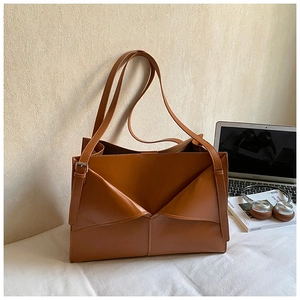 Dettaglio di borsa tote marrone con piega geometrica unica e design professionale