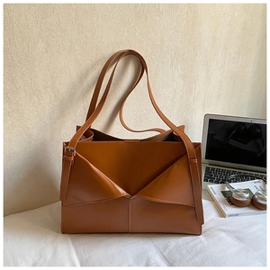 Dettaglio borsa tote in pelle marrone con patta a doppio triangolo e fibbie argentate