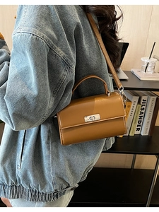 Détail du sac à bandoulière en cuir caramel avec fermoir rotatif argenté et style rétro