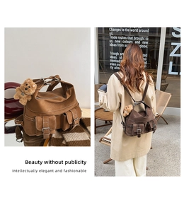 Detail of vintage brown leather backpack with front pockets and plush dog charm accessory