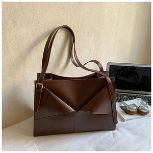 Dettaglio borsa tote marrone scuro con patta geometrica a V e tracolla regolabile