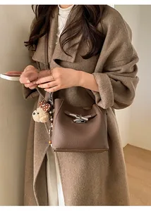 Detail of a dark brown lychee leather bucket bag featuring a silver metal plug-in lock