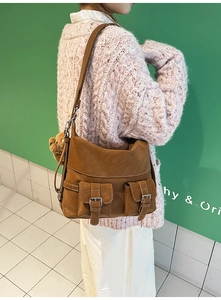 Brown vintage faux leather tote bag with double buckle pockets and mini bear charm detail