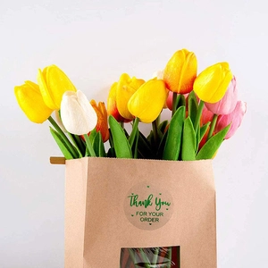 Colorful artificial tulip bouquet in kraft paper bag with Thank You sticker